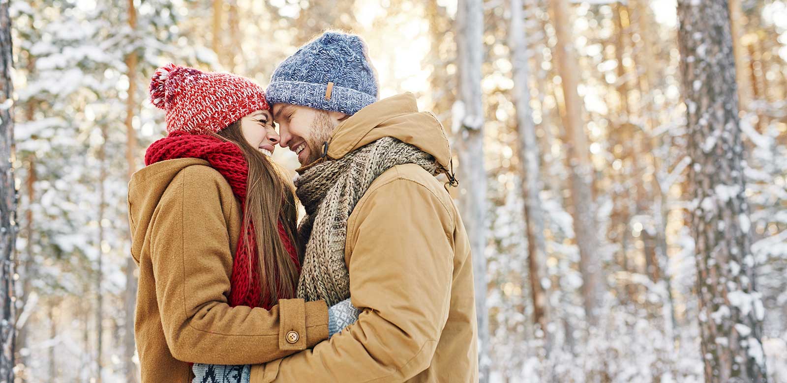 Two people standing the in woods in the snow - Pagosa Springs RiverWalk inn