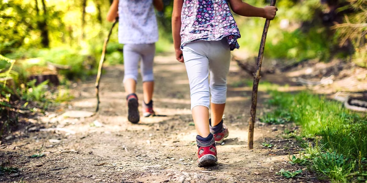 Girls are Hiking Pagosa Springs path wearing mountain boots and walking sticks