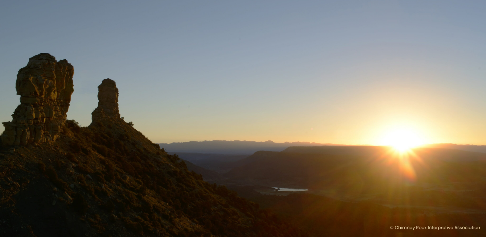 Chimney Rock at sunrise showcasing vibrant colored skies