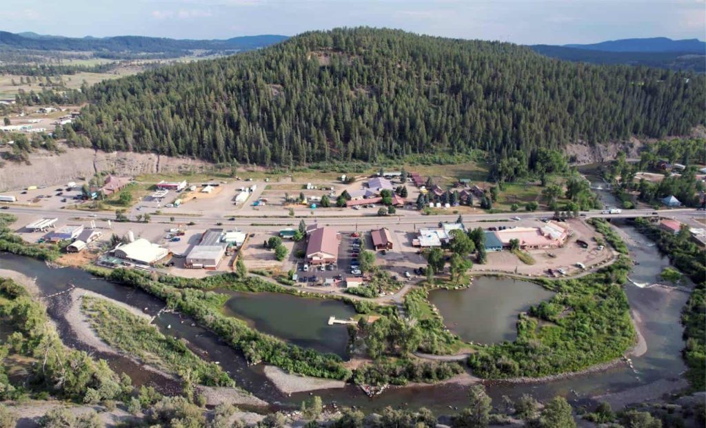 Aerial view of a small town with a winding river, showcasing buildings and greenery in the landscape.