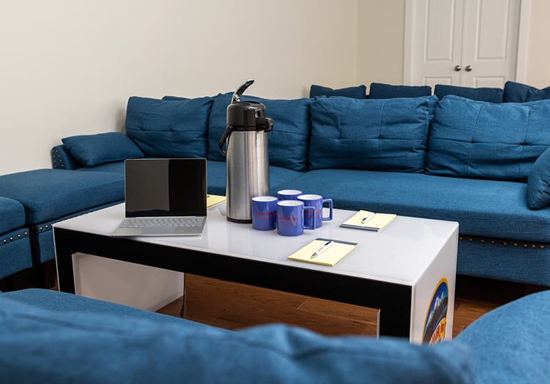 Breakout room with Coffee Carafe and mugs, and laptop
