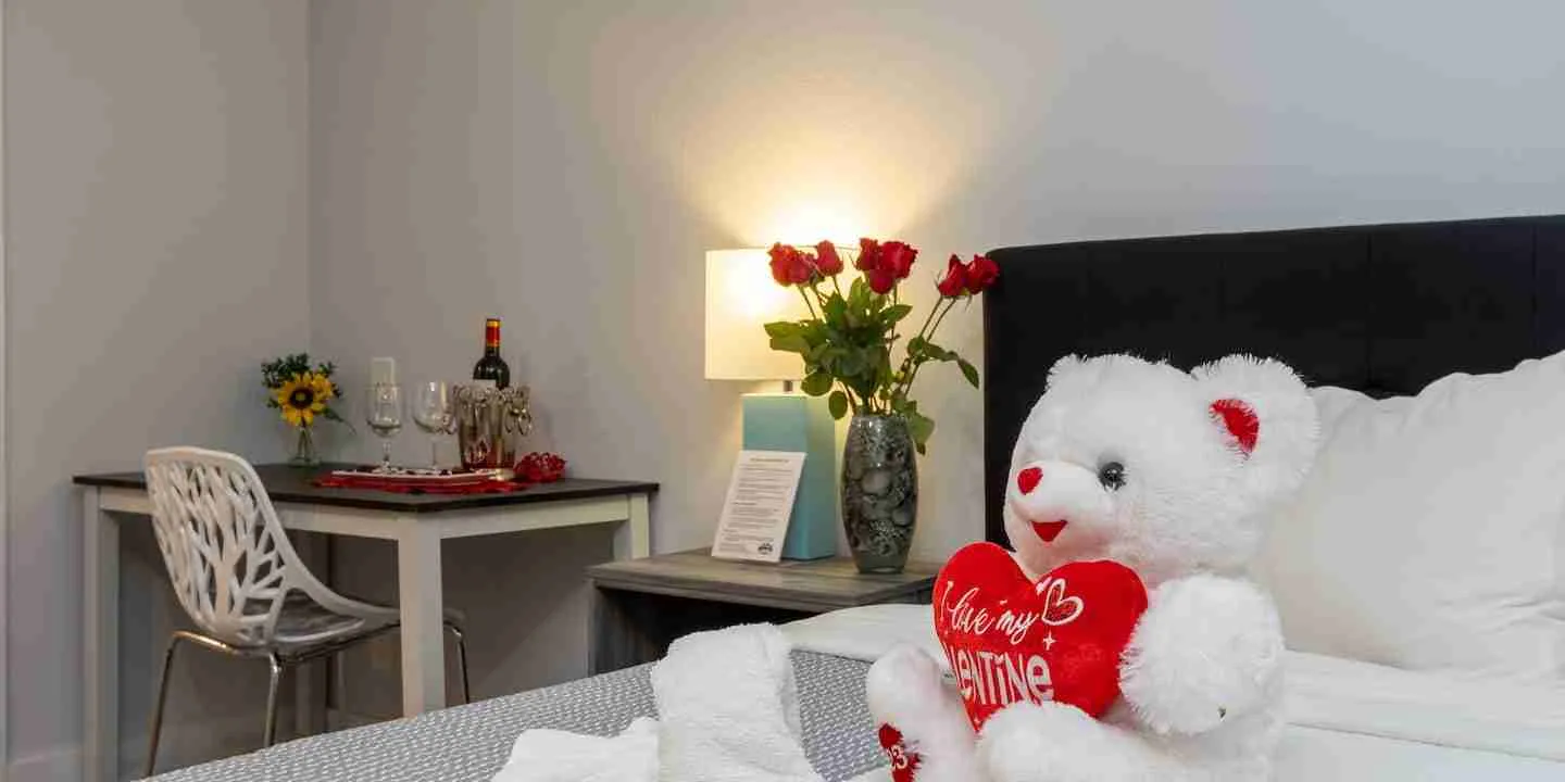 A room at our Pagosa Springs Hotel set up with a teddy bear, roses, and wine for Valentine's Day Weekend Getaways in Colorado